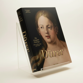 A hardcover art book titled 'Dürer: The Complete Printmaker' resting on a dark textured surface. The cover features a classical portrait painting of Albrecht Dürer with his name in large gold lettering.